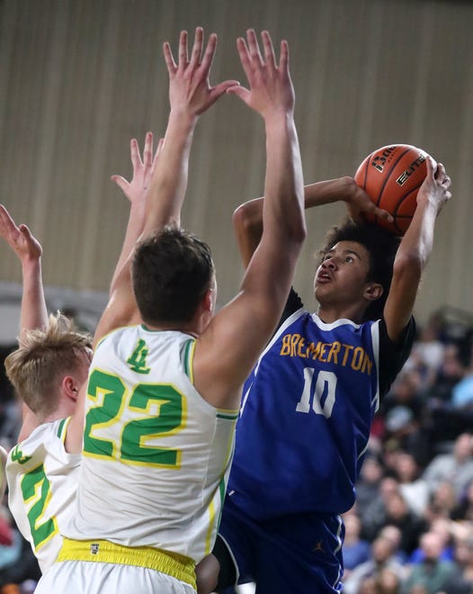 Bremerton’s Jalen Davis (10) goes up for a shot over Lynden’s Brant Heppner (22) and Brady Elsner (2) during their 2A boys basketball state semifinals in Yakima on Friday, March 1, 2024.