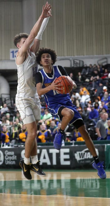 Bremerton’s Jalen Davis, left, goes up for a shot around North Kitsap’s Cade Orness during their 2A state championship game at the Yakima SunDome on Saturday, March 2, 2024. North Kitsap won the game gets a 71-48 and took home the third place trophy while Bremerton brought home fifth place.