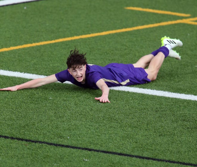 North Kitsap’s Harper Sabari celebrates his goal with a slide across the wet turf during their season opener against Skyline in Poulsbo on Saturday, March 9, 2024.
