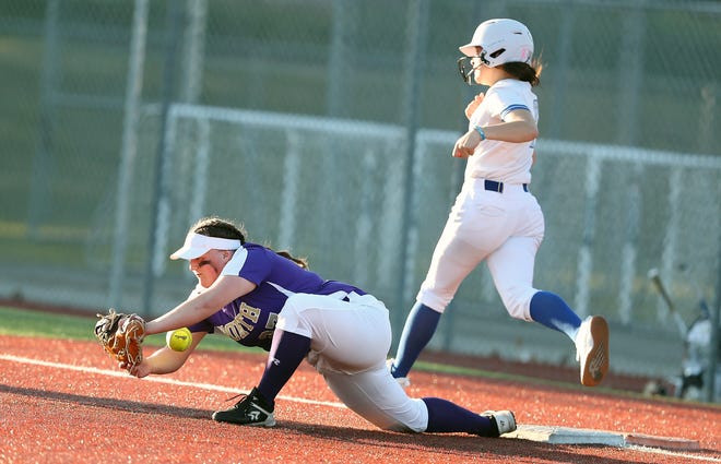 North Kitsap’s Kasey Wallace (27) loses control of the catch and Olympic’s Shaeinna Cherrey (7) is called safe at first on Tuesday, March 19, 2024. Cherrey was safe on the play.
