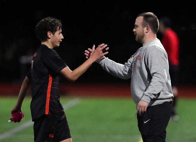 Central Kitsap head coach Patrick Leonard congratulates Silas Gholston as he comes off the field during the final minutes of their game against Gig Harbor in Silverdale on Thursday, March 21, 2024.