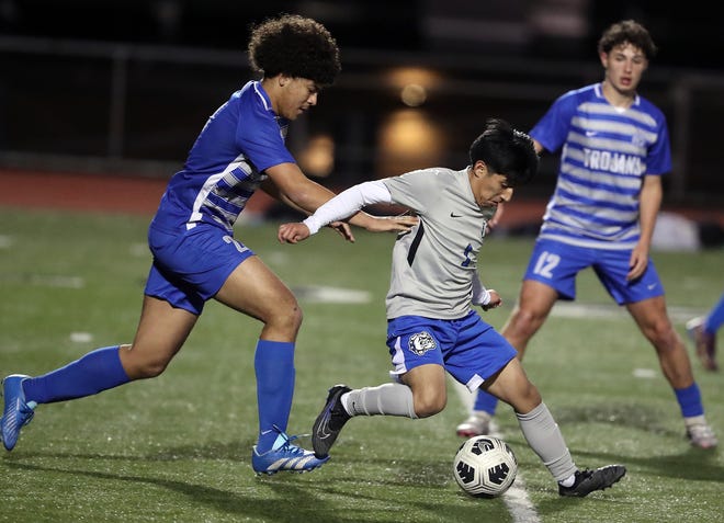 North Mason’s Christian Santiago (1) moves the ball down the field while under the pressure of Olympic’s Jeremiah Swain during their game on Tuesday, March 26, 2024. North Mason won the game 1-0.