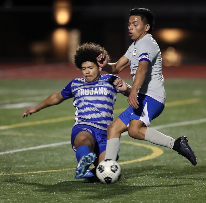 Olympic’s Jeremiah Swain (20) slide tackles North Mason’s Pedro Salvador during their game on Tuesday, March 26, 2024. North Mason won the game 1-0.