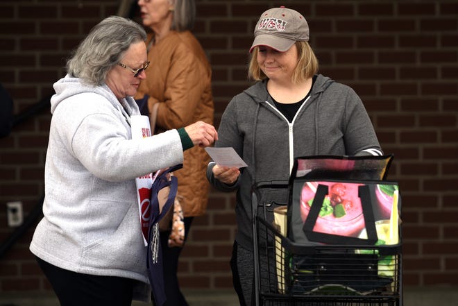 Sandy Pyle, left, who has worked at Albertsons for almost 20 years, hands a "stop the merger" leaflet to a customer, Wendy McGill, right, in front of Safeway at Port Orchard on April 5.